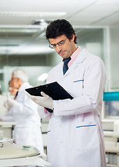 Image showing Male Researcher Reading Clipboard