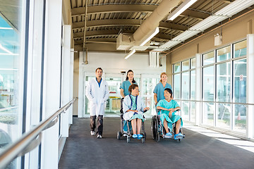 Image showing Medical Team With Patients On Wheelchairs At Hospital Corridor