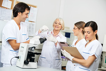 Image showing Scientists Discussing Over Blood Sample In Laboratory