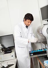 Image showing Scientist Loading Analyzer With Samples