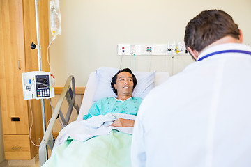 Image showing Male Patient Looking At Doctor While Lying On Hospital Bed