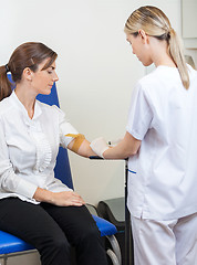 Image showing Nurse Drawing Blood From Businesswoman's Arm