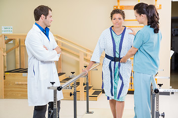 Image showing Physical Therapist With Doctor Assisting Female Patient In Walki