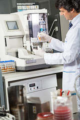 Image showing Scientist Using Urine Analyzer To Test Samples