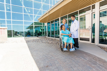 Image showing Nurse And Doctor Looking At Patient On Wheelchair At Courtyard