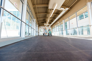 Image showing Nurses And Doctor With Patients On Wheelchairs At Hospital Corri