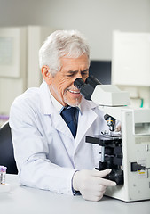 Image showing Smiling Scientist Using Microscope In Laboratory