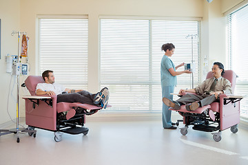 Image showing Nurse Adjusting IV Machine While Patients Reclining On Chair