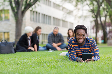 Image showing Student With Digital Tablet On Grass At Campus Park