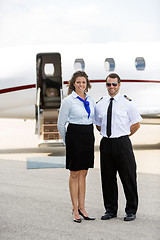 Image showing Airhostess And Pilot Standing Against Private Jet