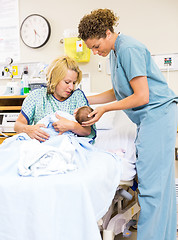 Image showing Nurse Helping Woman In Holding Newborn Baby At Hospital