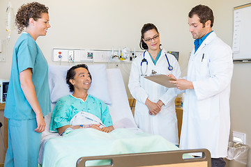 Image showing Doctors Discussing Notes While Nurse And Patient Looking At Them