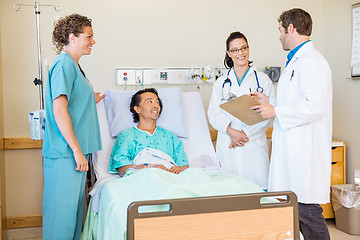 Image showing Doctors Discussing Report While Nurse And Patient Looking At The