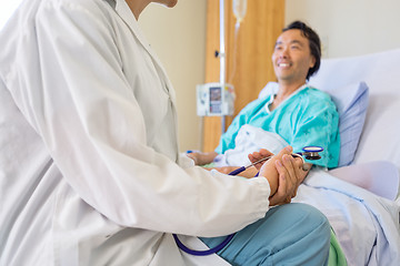 Image showing Doctor Sitting With Patient On Hospital Bed