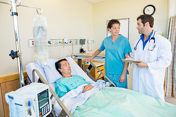 Image showing Medical Team Looking At Each Other While Patient On Bed