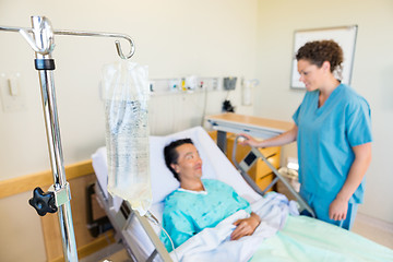 Image showing IV Bag With Nurse And Patient Looking At Each Other