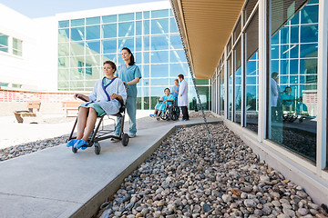 Image showing Medical Team With Patients On Wheelchairs At Hospital Courtyard