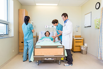 Image showing Nurses And Doctor Examining Patient In Hospital