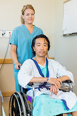 Image showing Patient Sitting On Wheelchair While Nurse Assisting Him