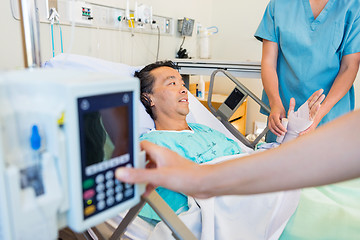 Image showing Nurse Putting Bandage On Patient's Hand While Coworker Operating