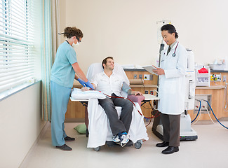 Image showing Doctor Using Digital Tablet With Nurse Giving Dialysis To Patien