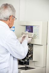 Image showing Scientist Loading Analyzer With Samples