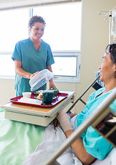 Image showing Nurse Lifting Cover From Food Plate For Patient In Hospital