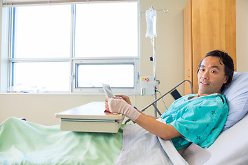 Image showing Patient Holding Digital Tablet While Reclining On Bed