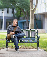 Image showing Male Student Using Digital Tablet On Bench At Campus