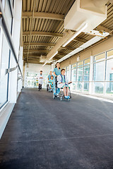 Image showing Female Nurses Pushing Patients On Wheelchairs At Hospital Corrid