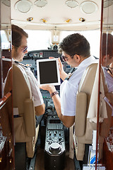 Image showing Pilot Showing Digital Tablet To Copilot In Cockpit