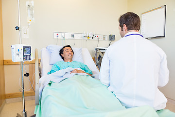 Image showing Mature Patient Looking At Doctor While Lying On Hospital Bed