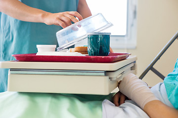 Image showing Nurse Lifting Cover From Tray For Patient In Hospital