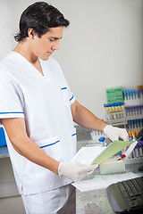 Image showing Technician With Samples Analyzing Document