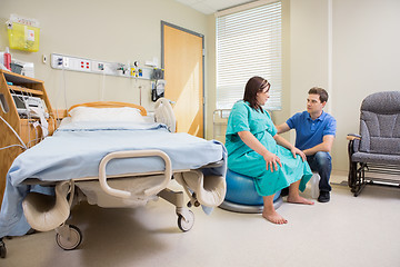 Image showing Man Looking At Pregnant Wife On Exercise Ball In Hospital
