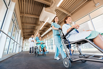 Image showing Nurses Pushing Patients On Wheelchairs With Doctor At Corridor