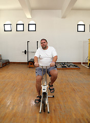 Image showing overweight man on bike simulator