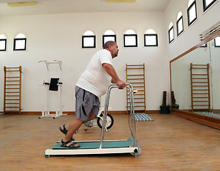 Image showing overweight man running on trainer treadmill