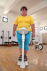 Image showing women with overweight on scales in gym