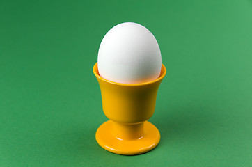 Image showing Egg in cup at green background