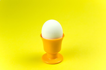 Image showing Egg in cup at yellow background