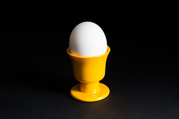 Image showing Egg in cup at black background