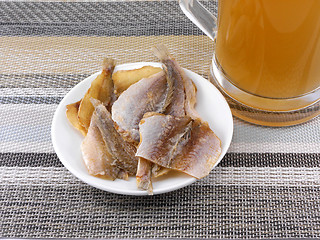 Image showing smoked fish and cup of beer on a background