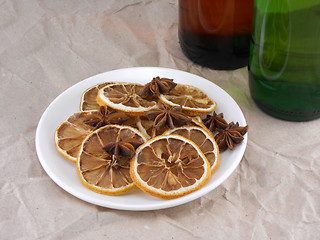 Image showing beer bottle with cinnamon and lemon on white plate