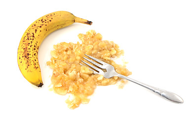 Image showing Overripe unpeeled banana with fork and pureed fruit