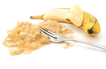 Image showing Closeup of half-peeled banana with a fork in mashed puree