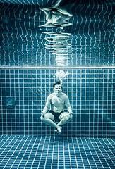 Image showing Man under water in a swimming pool to relax in the lotus positio