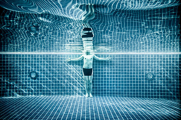 Image showing Persons standing under water in a swimming pool