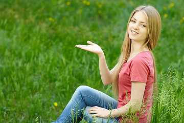 Image showing Woman outdoors holding blank space on her palm