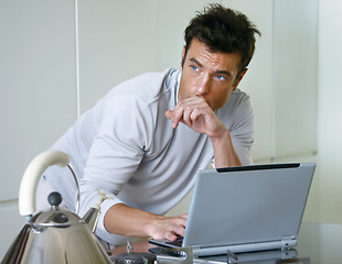 Image showing man with computer in kitchen